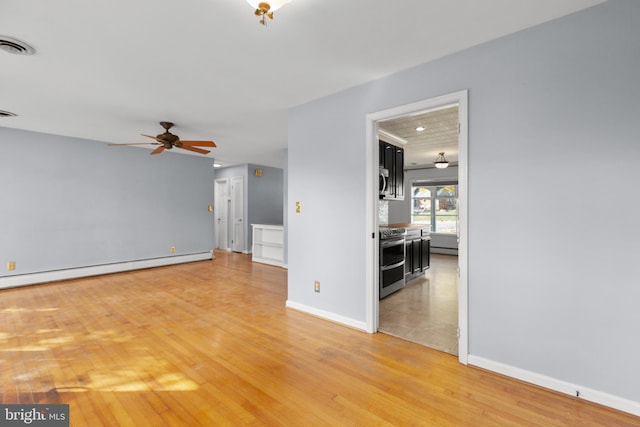 spare room with light hardwood / wood-style floors, ceiling fan, and a baseboard heating unit