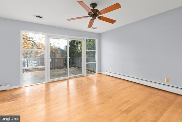 spare room featuring ceiling fan, baseboard heating, and light hardwood / wood-style floors