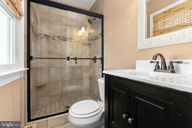 bathroom with vanity, walk in shower, tile patterned flooring, and toilet