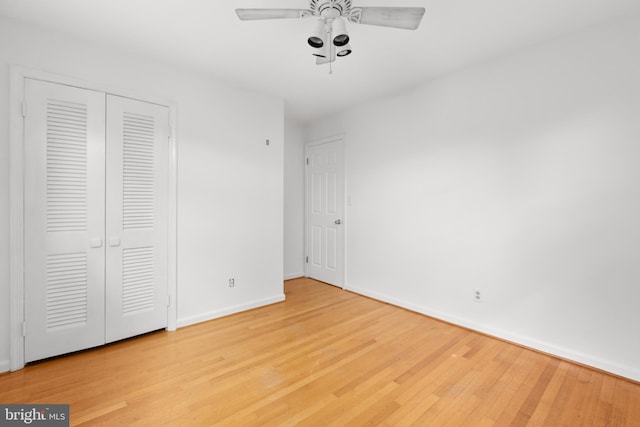 unfurnished bedroom with a closet, hardwood / wood-style flooring, and ceiling fan