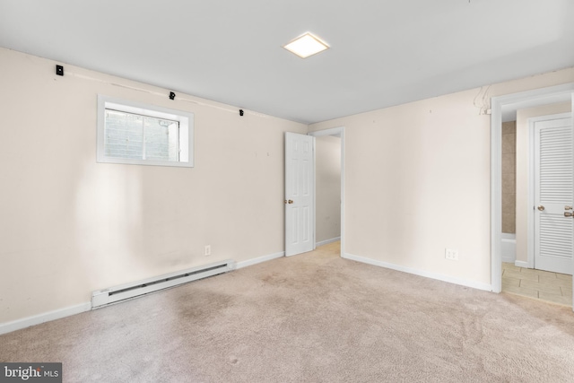 carpeted spare room featuring a baseboard heating unit