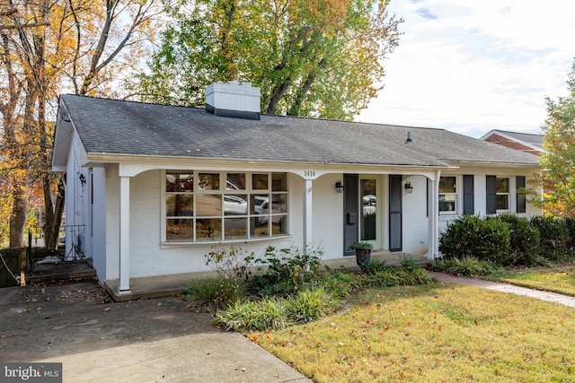 single story home featuring covered porch and a front yard