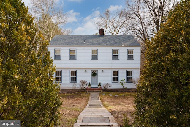 colonial house with roof with shingles and a chimney