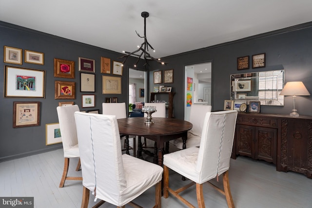 dining space featuring an inviting chandelier, baseboards, and wood finished floors