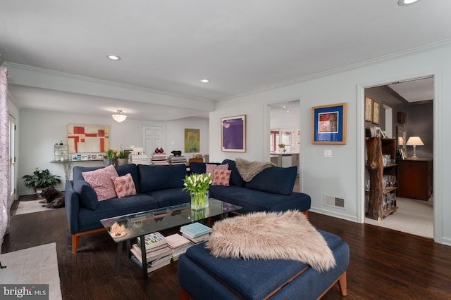 living room featuring ornamental molding, wood finished floors, visible vents, and baseboards