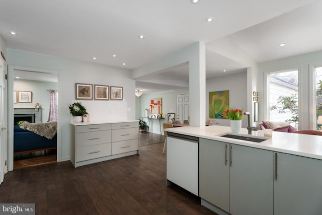 kitchen with dishwasher, dark wood-type flooring, light countertops, gray cabinetry, and a sink