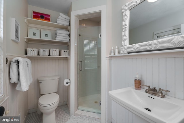 bathroom with tile patterned flooring, a sink, toilet, and a shower stall