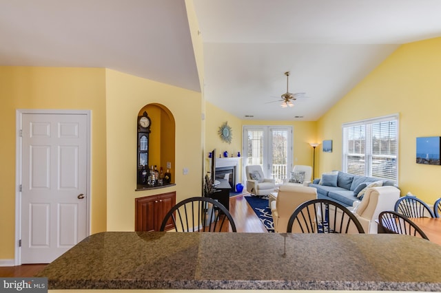 dining space with ceiling fan, hardwood / wood-style flooring, and lofted ceiling