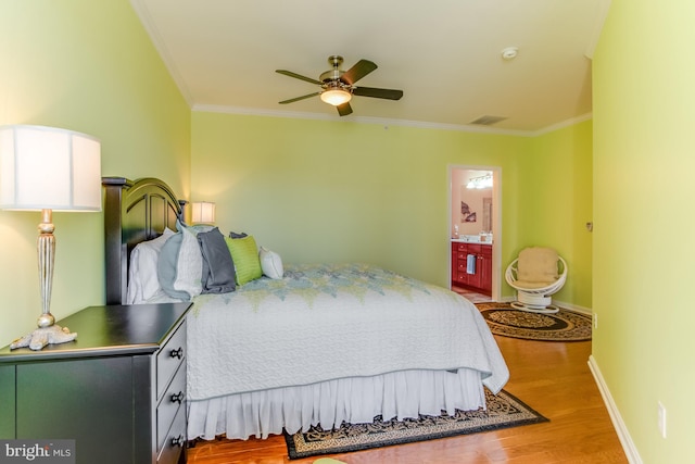 bedroom with ornamental molding, ceiling fan, wood-type flooring, and connected bathroom