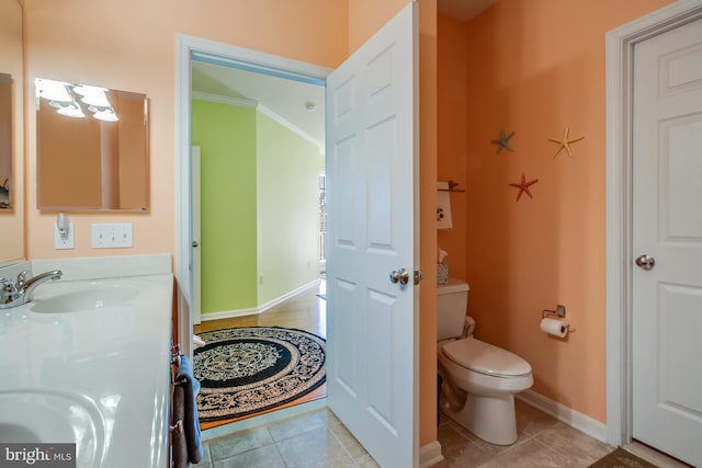 bathroom featuring tile patterned floors, crown molding, vanity, and toilet