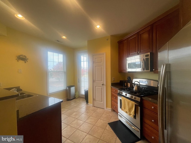 kitchen with light tile patterned floors, stainless steel appliances, and sink