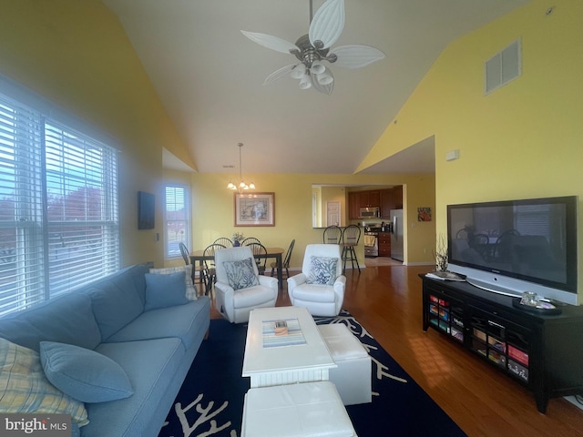 living room featuring ceiling fan with notable chandelier, dark hardwood / wood-style flooring, and high vaulted ceiling