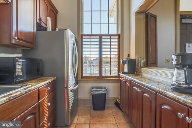 kitchen with light stone counters, sink, and light tile patterned flooring