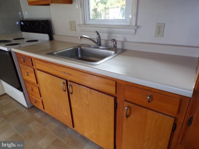 kitchen with decorative backsplash, white range with electric stovetop, and sink