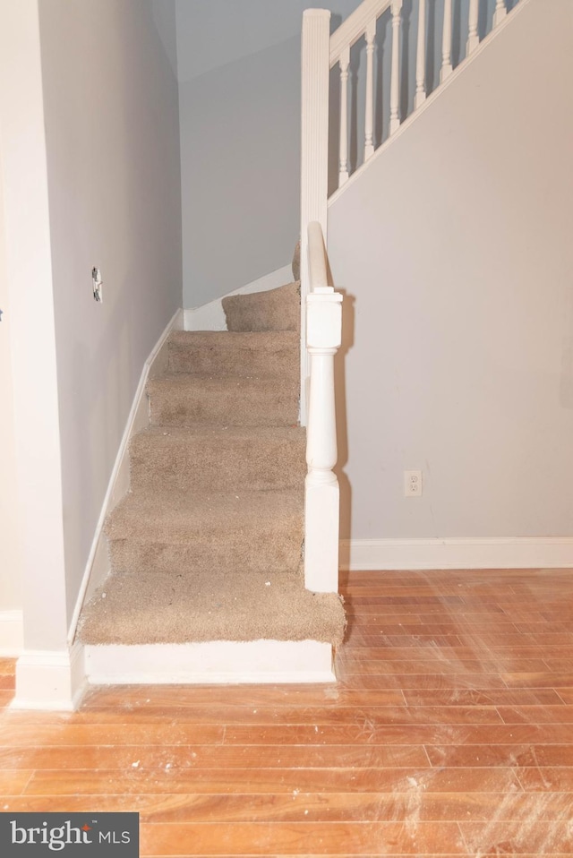 stairs featuring hardwood / wood-style floors