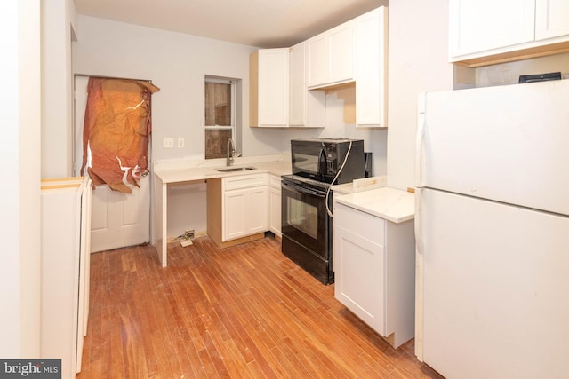 kitchen featuring black appliances, white cabinetry, sink, and light hardwood / wood-style flooring