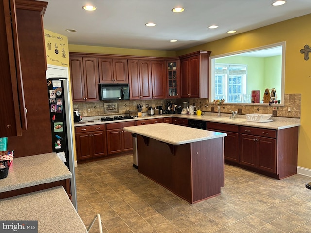 kitchen featuring decorative backsplash, stainless steel appliances, a kitchen island, and a breakfast bar