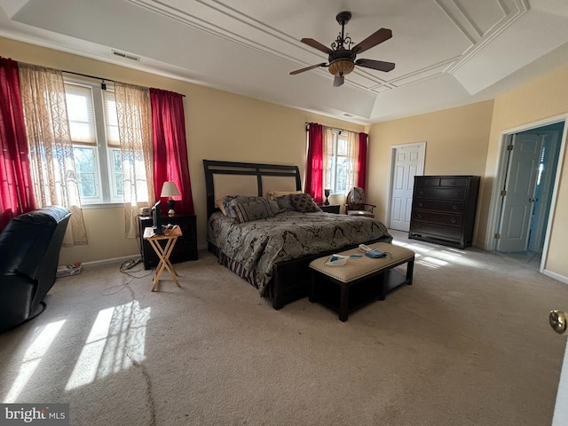 carpeted bedroom featuring ceiling fan and a tray ceiling