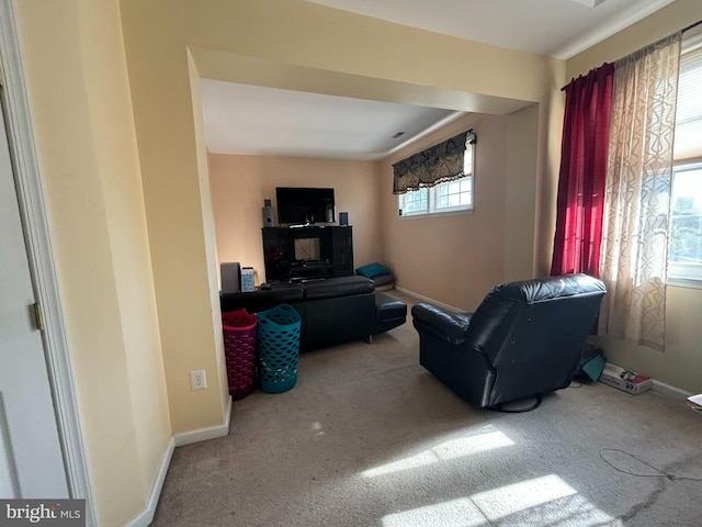 living room with a wealth of natural light and carpet flooring