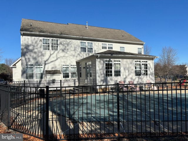 rear view of house with a covered pool