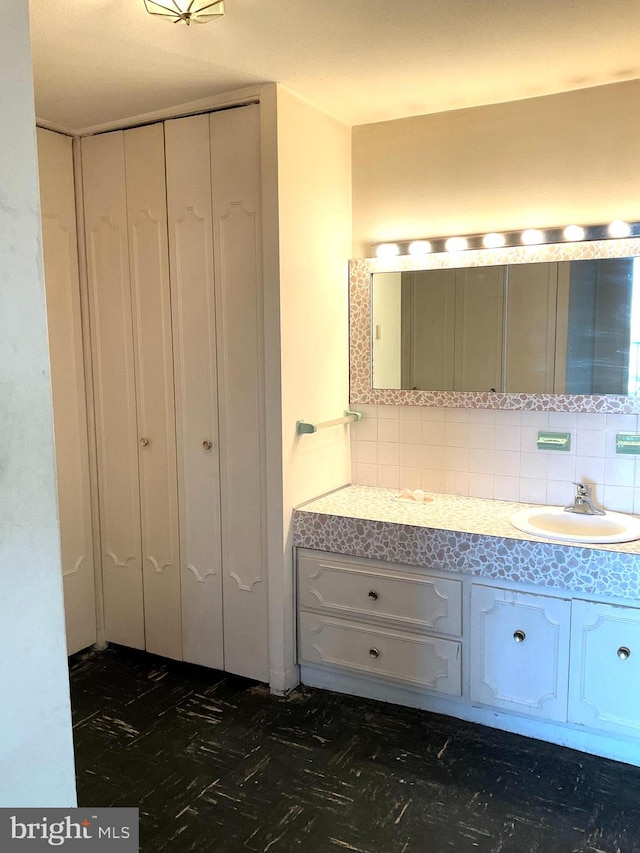 bathroom featuring vanity and backsplash