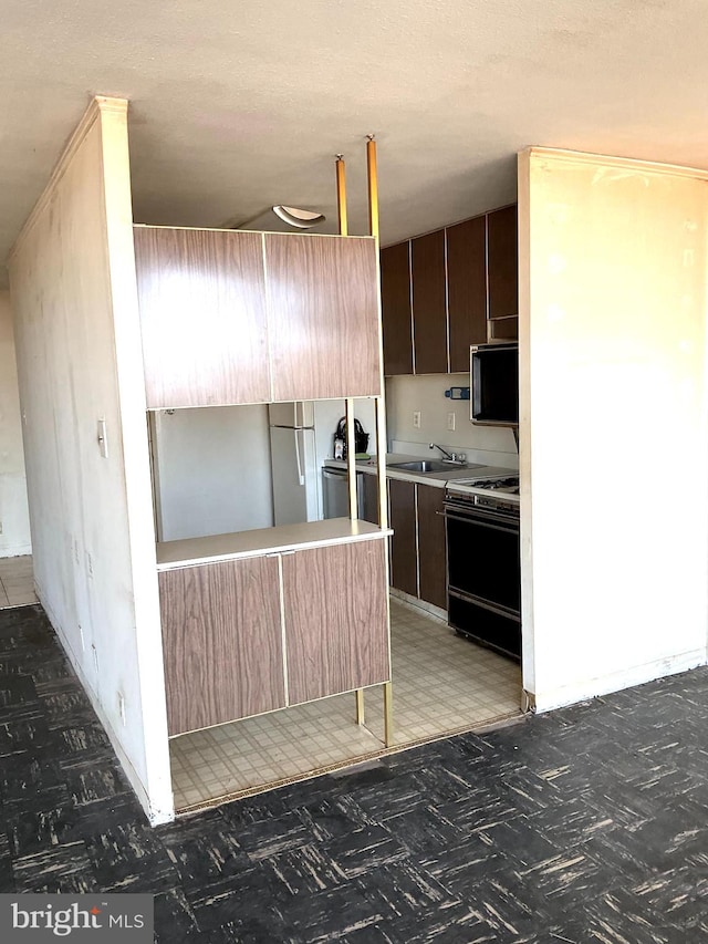 kitchen featuring kitchen peninsula, sink, and black range