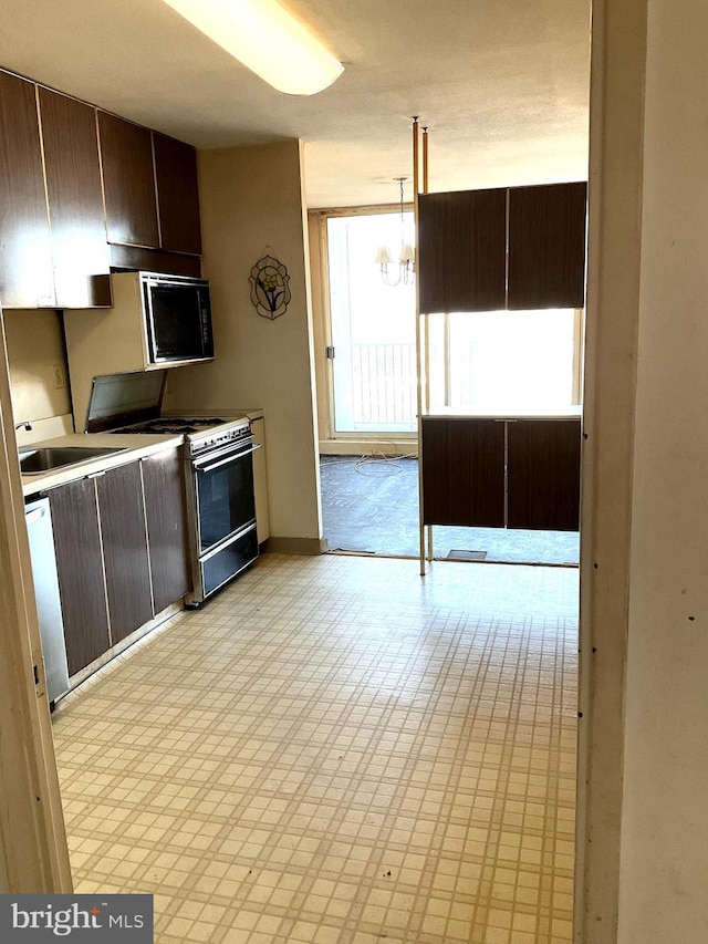 3900 Ford Rd Unit 11R, Philadelphia, PA 19131 - kitchen featuring white range with gas cooktop, a chandelier, dark brown cabinets, and light countertops