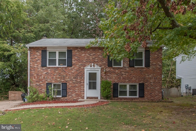 bi-level home featuring a front lawn and cooling unit