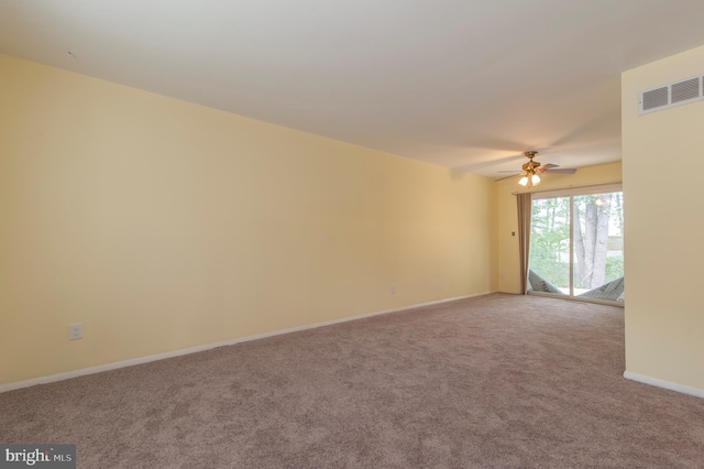 carpeted spare room featuring ceiling fan