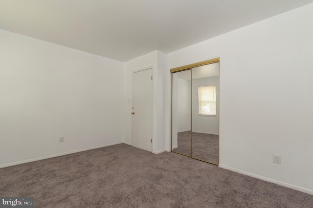 unfurnished bedroom featuring carpet and a closet