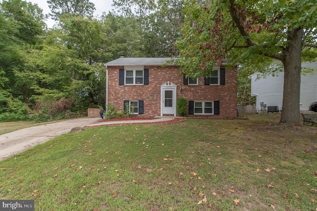 split foyer home with central AC unit and a front yard