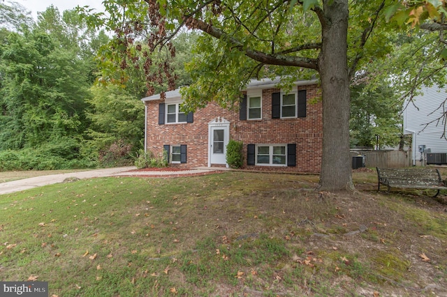 raised ranch featuring a front yard and central AC unit