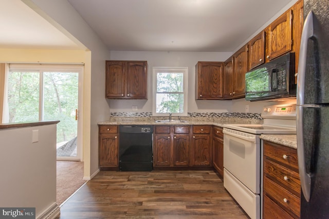 kitchen featuring a wealth of natural light, dark wood-type flooring, and black appliances