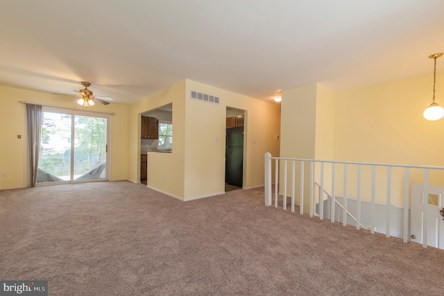 spare room featuring light carpet and ceiling fan