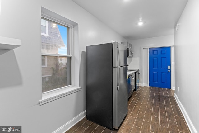 kitchen with appliances with stainless steel finishes and dark hardwood / wood-style floors