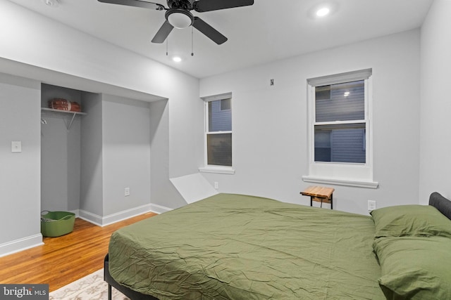 bedroom with a closet, wood-type flooring, and ceiling fan