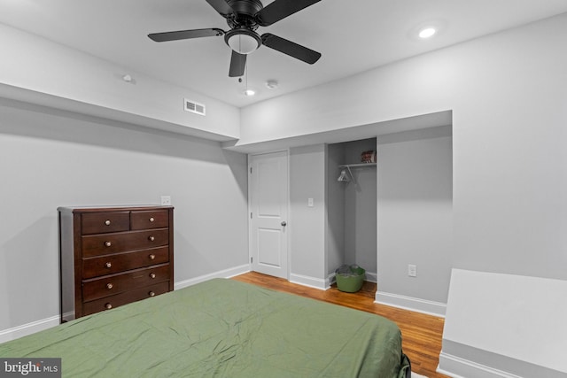 bedroom with a closet, hardwood / wood-style floors, and ceiling fan