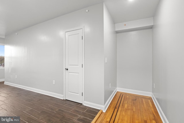 unfurnished room with dark wood-type flooring