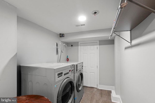 washroom with washing machine and dryer and wood-type flooring