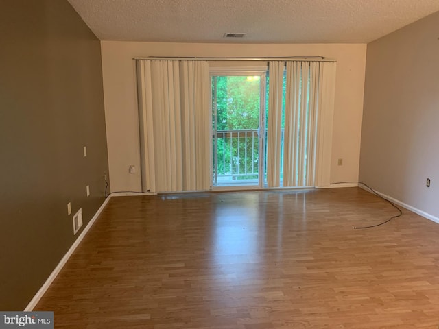 spare room with wood-type flooring and a textured ceiling