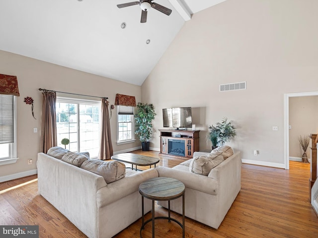 living room with ceiling fan, beamed ceiling, high vaulted ceiling, and light hardwood / wood-style floors