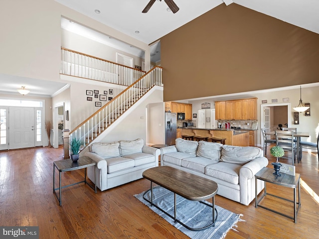 living room featuring hardwood / wood-style floors, high vaulted ceiling, and ceiling fan