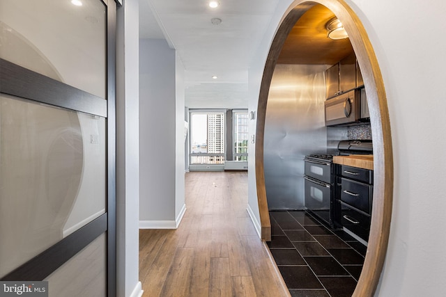 kitchen featuring decorative backsplash, black / electric stove, and dark hardwood / wood-style floors