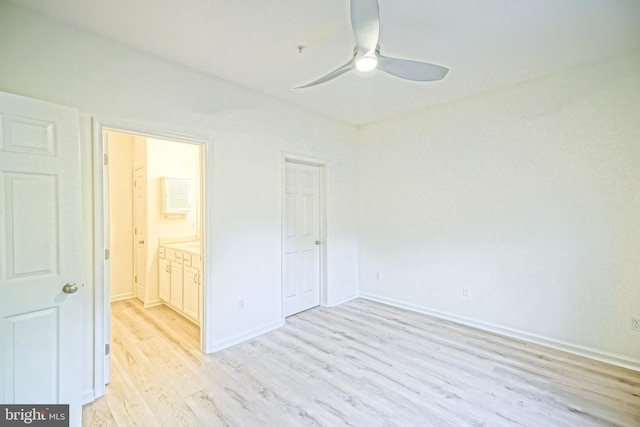 unfurnished bedroom featuring ceiling fan, ensuite bath, and light wood-type flooring