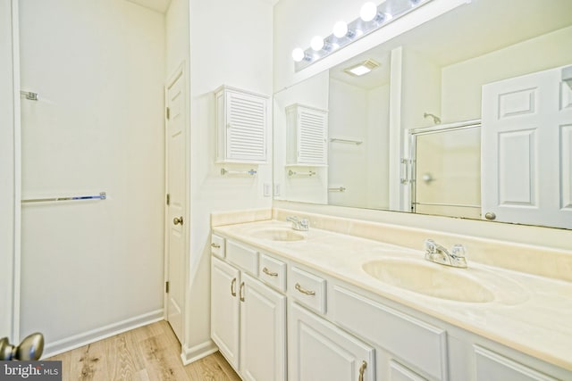 bathroom featuring vanity, an enclosed shower, and wood-type flooring