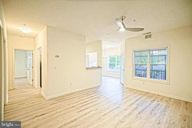 empty room featuring light wood-type flooring, a textured ceiling, and ceiling fan