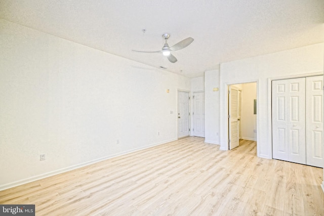 unfurnished bedroom featuring light wood-type flooring, ceiling fan, and a closet