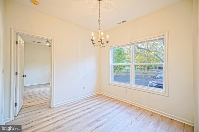 empty room featuring light hardwood / wood-style flooring and a notable chandelier