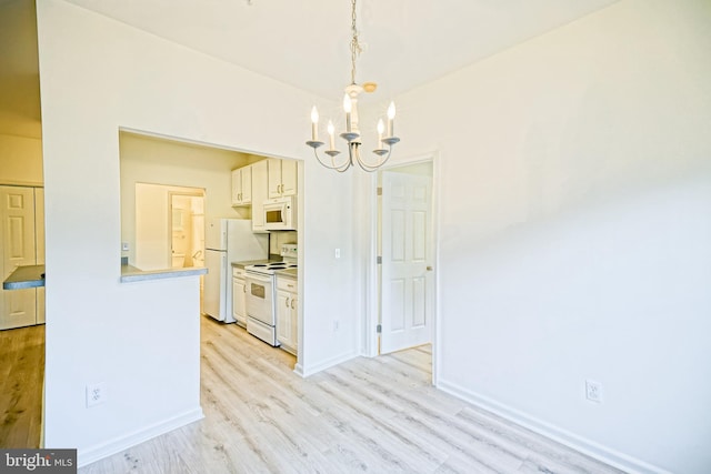 kitchen featuring an inviting chandelier, white appliances, decorative light fixtures, and light hardwood / wood-style floors