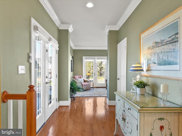 doorway featuring ornamental molding, light wood-type flooring, and french doors